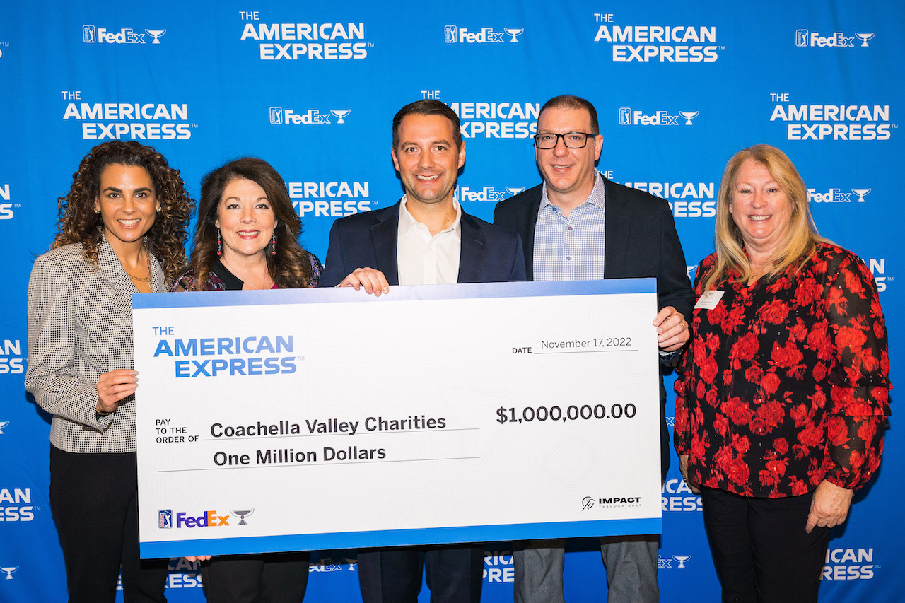 people standing behind charity check and smiling