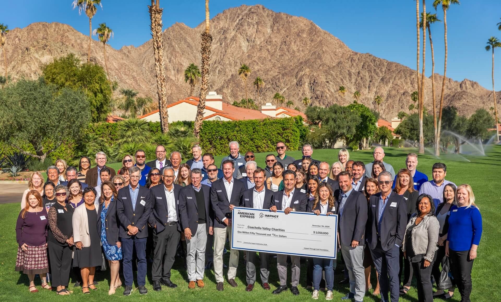 people standing behind charity check and smiling