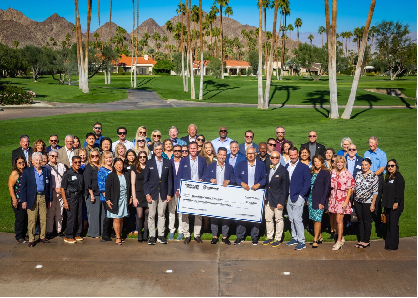 people standing behind charity check and smiling